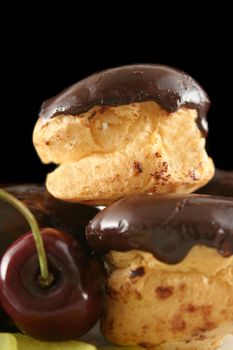 Chocolate profiteroles with a cherry.