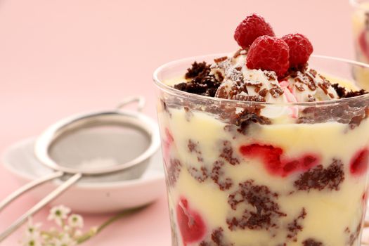 Delicious chocolate trifle dessert served in a glass topped with raspberries.