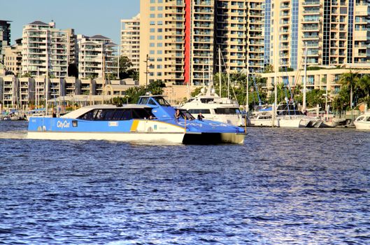 BRISBANE, AUSTRALIA - June 17 2009: City cat passes by riverfront apartment towers in Brisbane Australia. The city cat ferry service began in 1996 and now has 13 vessels. They are named after Aboriginal place names.