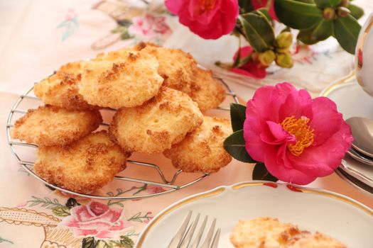 Fresh baked coconut macaroons ready to serve with a camellia.