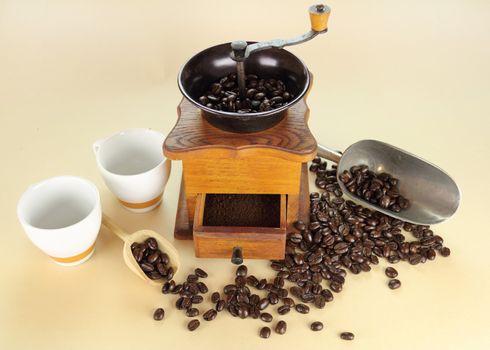 Old fashioned coffee grinder with coffee beans and ground coffee in the drawer.