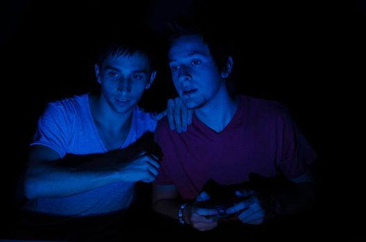 Two friends in front of a computer screen gaming