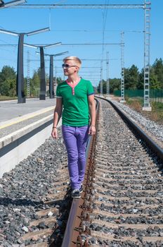 Shot of one man walking on train tracks