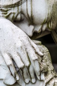 detail of a mourning sculpture on a cemetery