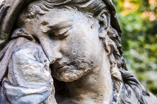 detail of a mourning sculpture on a cemetery