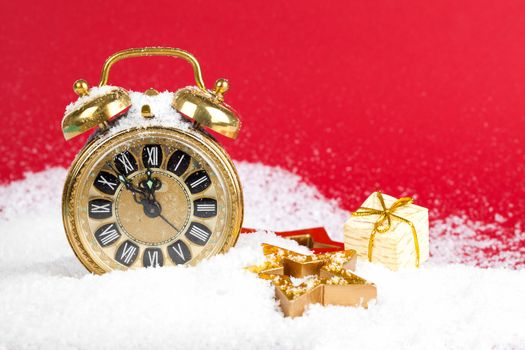 vintage christmas decoration golden star and antique golden clock in snow on red background