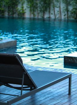 Closeup chaise longue with swimming pool background