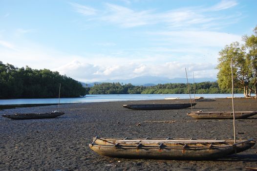 Timber canoe at sand near river, Papua New Guinea