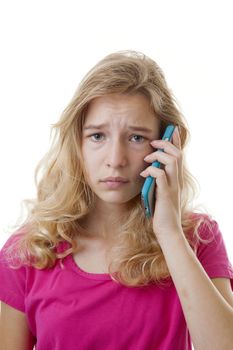 Girl is calling on mobile phone over white background looking sad