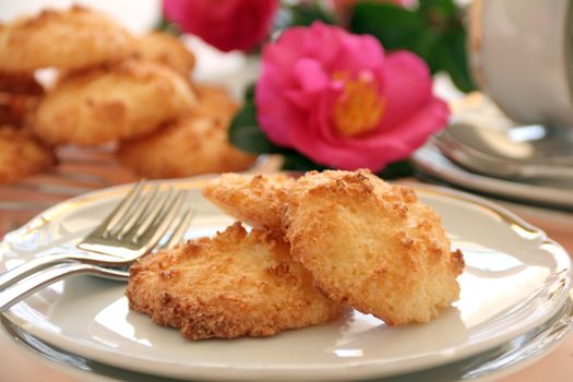 Fresh baked coconut macaroons ready to serve with a camellia.