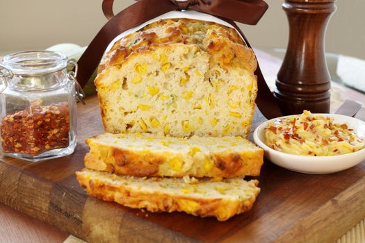 Freshly sliced corn bread with chili butter and chili flakes.