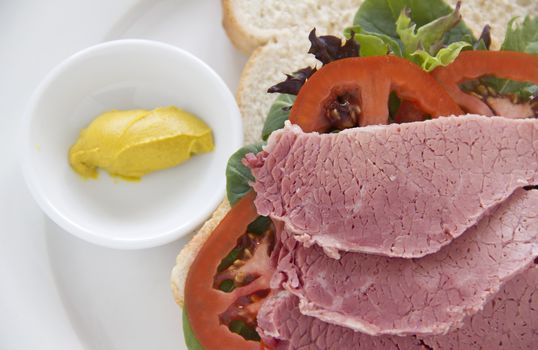 Delicious corned beef open sandwich with mustard and fresh garden salad.