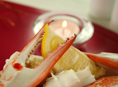 Fresh cracked crab claw with a slice of lemon ready to serve.