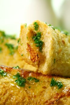 Vegetarian baked corn rolls dripping with parsley butter on a bed of mixed lettuce.