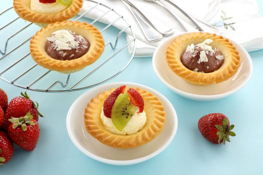 Delicious and decadent cream and chocolate tarts with fresh strawberries.