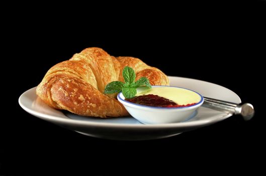 Delicious crisp and fresh croissant with jam and butter.