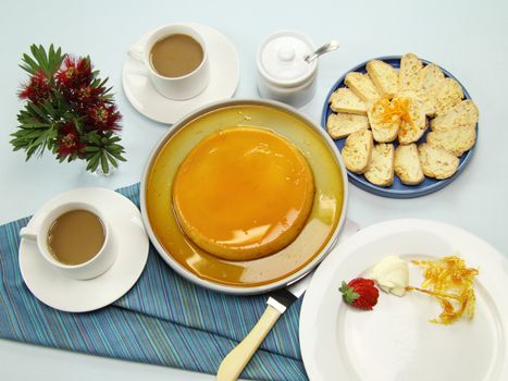 Delicious creme caramel with almond and orange biscuit and coffee.