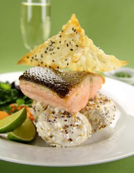 Delicious crispy skin salmon with fried wontons on a bed of mustard potatoes.