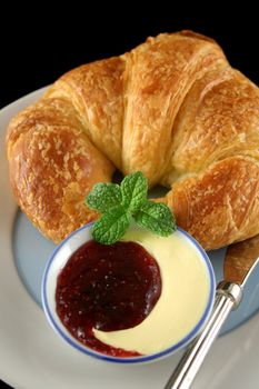 Delicious crisp and fresh croissant with jam and butter.