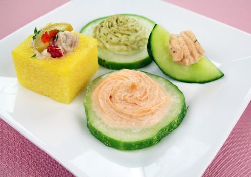 Cucumber rounds with avocado, salmon and cream cheese with a tuna polenta.
