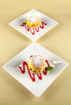 Custard pastry cakes in a line diagonally on plates.