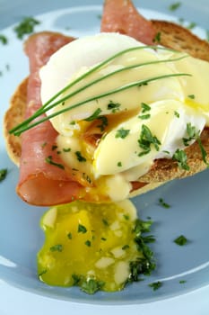 Delicious breakfast of eggs benedict with beautiful rich hollandaise sauce.