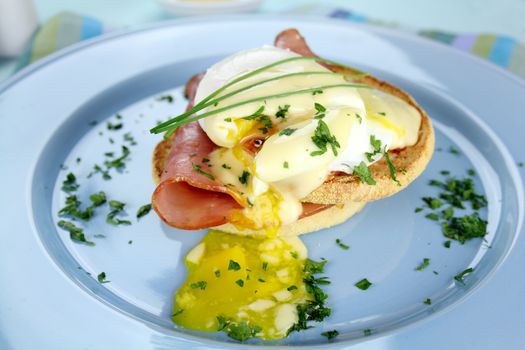 Delicious breakfast of eggs benedict with beautiful rich hollandaise sauce.