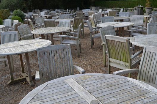 Wooden patio tables and chairs at an outside party venue before the festivities begin.