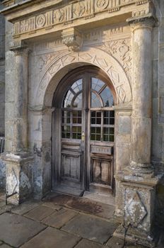 Stone arched doorway with wooden door.