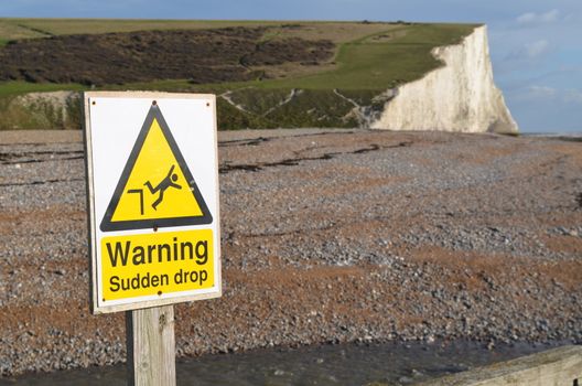 Sudden drop sign with cliffs in the background.Image of the Seven Sisters cliffs along the South East coast of England.Shot taken in Autumn 2013.