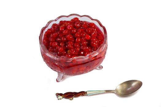 Bright red berries in a crystal vase filled with sugar syrup. Presented on a white background.