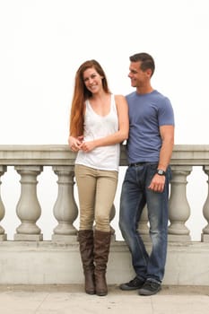 Young couple sitting on a bridge.