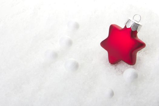 red christmas bauble as christmas star on snow 