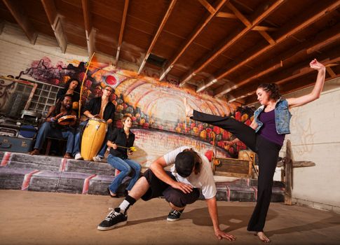 Man dodging a woman kicking during a capoeira performance