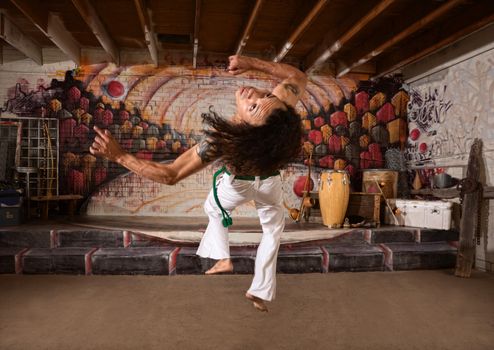 Young capoeira expert flipping over indoors