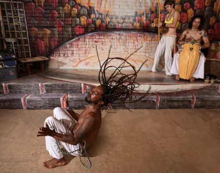 Group of capoeira performers in action and playing music