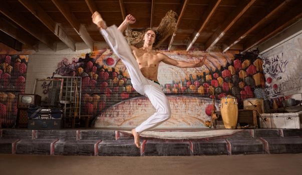 Handsome capoeira performers demonstrating a flying kick