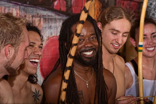 Handsome Brazilian man with group of capoeira performers