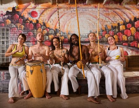 Group of six capoeira performers playing instruments and singing