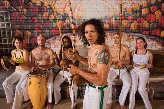 Handsome Latino Capoeira expert with musical instruments
