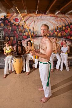 European capoeira performers with group playing music indoors