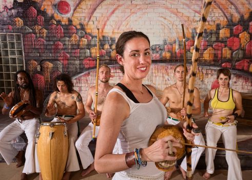 Young group of capoeira musicians in urban building