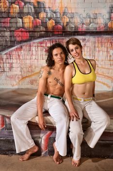 Cute mixed couple in capoeira outfit indoors