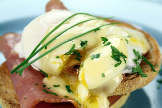 Delicious breakfast of eggs benedict with beautiful rich hollandaise sauce.