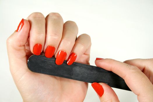 Female filing her fingernails with an emery board.