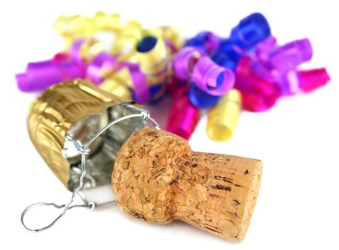 Champagne cork and wire cap in front of party decoration.
