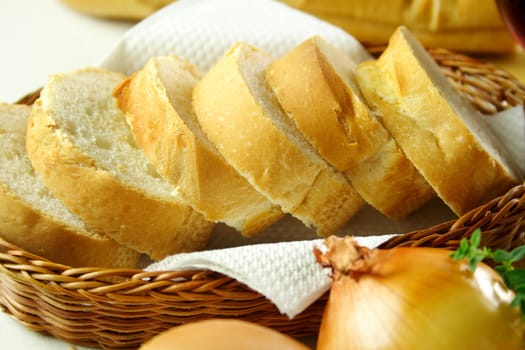 Sliced french stick in a basket in a table setting.