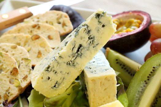 Delicious fruit and blue cheese platter featuring a variety of different cheeses and fresh fruits.