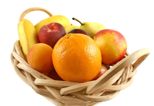 Cane basket filled with freshly picked colorful organic fruit.