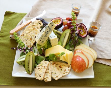 Delicious fruit and cheese platter featuring a variety of different cheeses and fresh fruits.